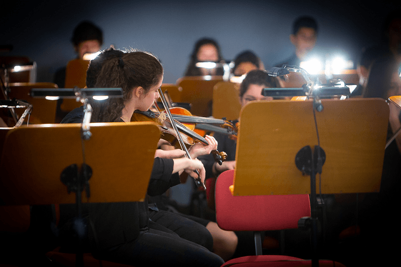 No primeiro plano, violista de perfil e, ao fundo, outros músicos da Orquestra Juvenil de Lisboa, durante o espetáculo 