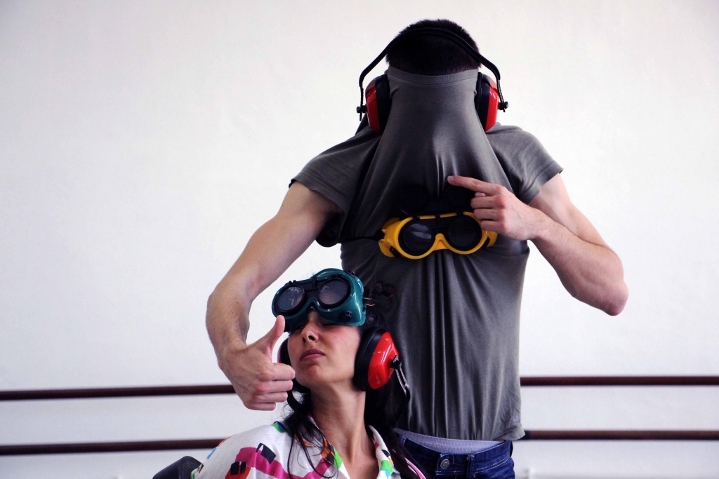 Fotografia dos dois interpretes do espetáculo com óculos de mergulho e headphones coloridos