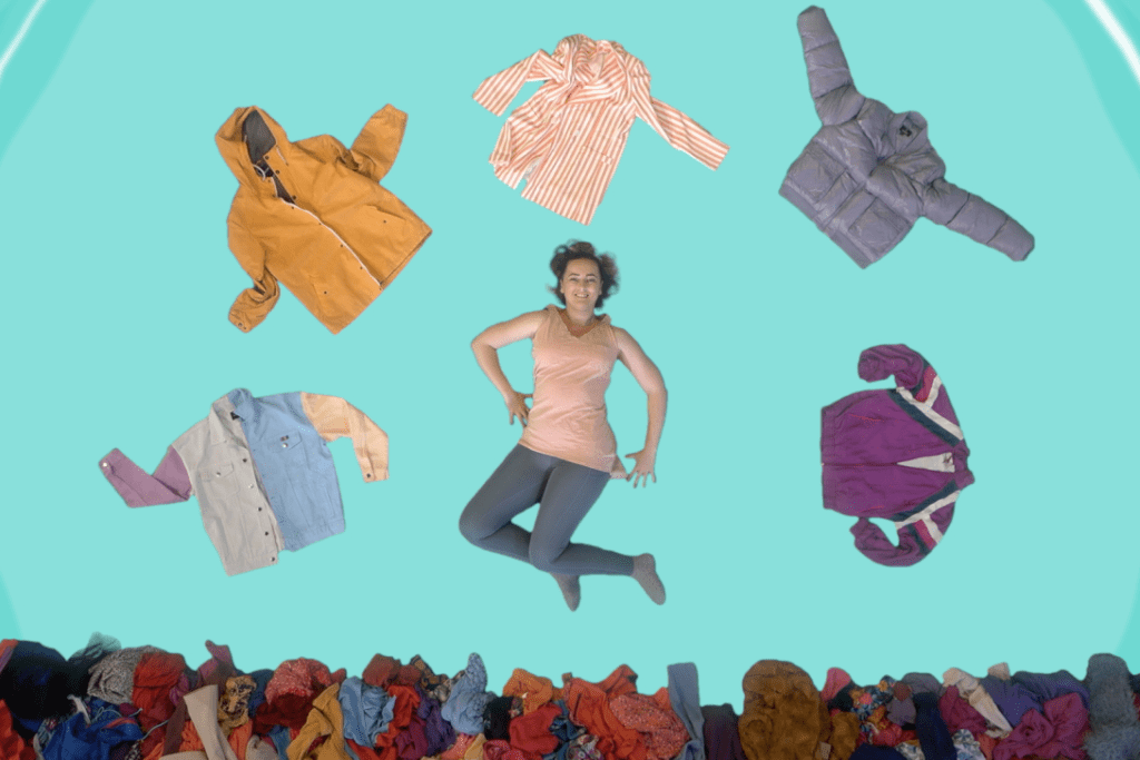 Uma mulher deitada no chão, vista a partir de um ângulo superior, rodeada por camisolas de várias cores.