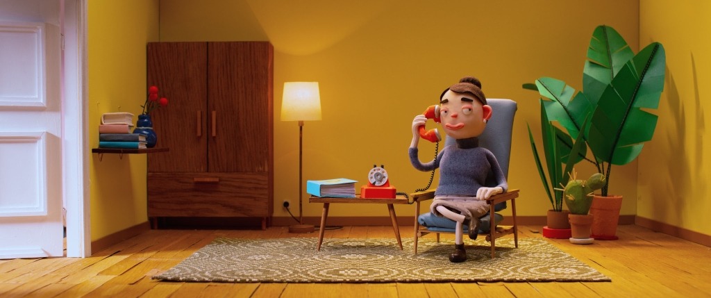 Imagem do filme Matilda com uma pessoa sentada numa poltrona com o auscultador do telefone fixo ao ouvido.